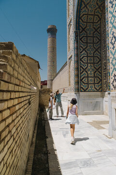 Family exploring historic tiled architecture in Uzbekistan.
