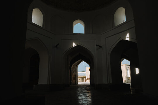 Dark interior of a historic building with arched doorways in Bukhara