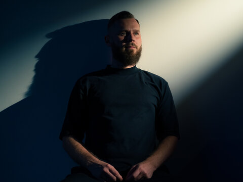 Thinking man portrait in light and shadow 