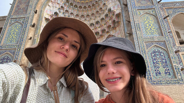 Woman and girl taking a selfie in front of Abdulaziz Khan Madrassah