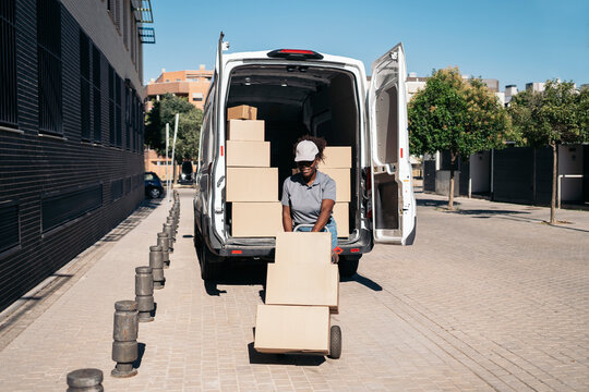African american courier delivering packages from van