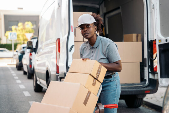 Female delivery worker moving packages from white van