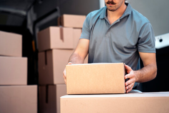 Delivery man stacking packages from vehicle