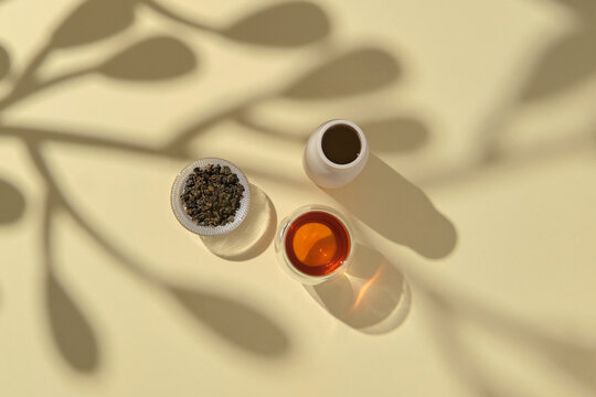 An overhead view showcases tea, cups, and shadows
