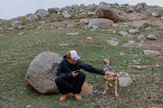 A Man and His Puppy on a Rocky Slope.