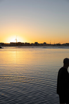 Abstract sunset over rippled water with man almost out of frame
