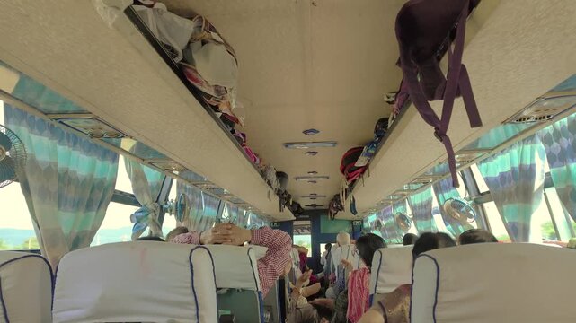 Interior Shot Of Indian Public Transport Bus Showing Crammed Overhead Luggage Racks And Cabin Fans