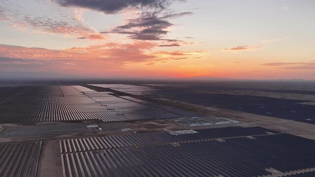 Stunning Sunset over Vast Solar Panel Farm in Remote Sandy Desert Landscape