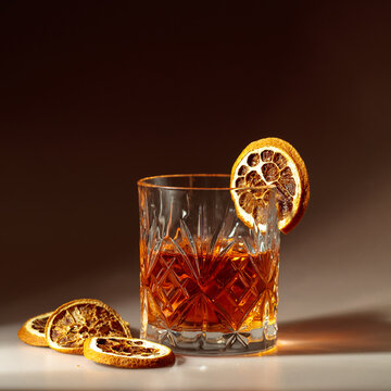 Refreshing rum cocktail garnished with dried orange slice.