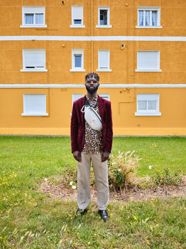 Stylish young man with sunglasses posing in front of urban building