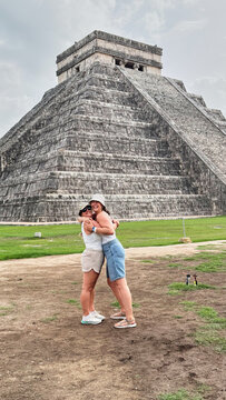 Friends hugging at Chichen Itza pyramid in Mexico