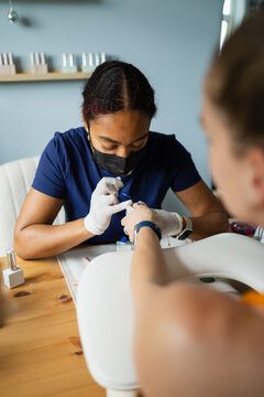 Beauty professional performing a gel manicure