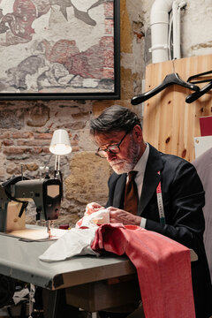 Tailor Sewing at Machine in Artisan Workshop