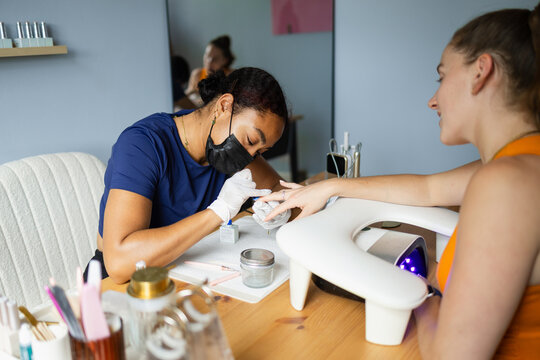 Nail artist performing a gel manicure