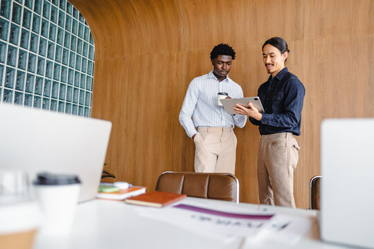 Two People Discussing Ideas in a Modern Office With Wood Walls