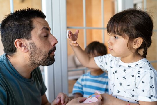 Girl Applying Pretend Makeup To Father
