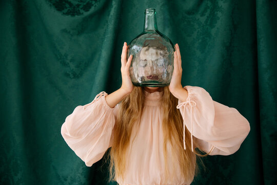 Woman holding large glass bottle 
