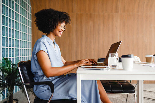 Woman Works on Laptop in Modern Office Space During Daytime