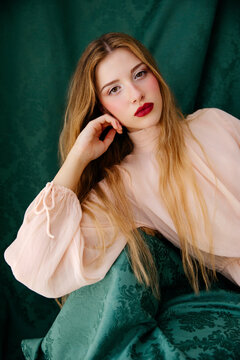 Woman posing against green fabric