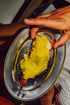 Customer taking a creative pineapple dessert that mimics a pizza slice
