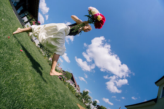 A woman running with a bouquet of flowers.