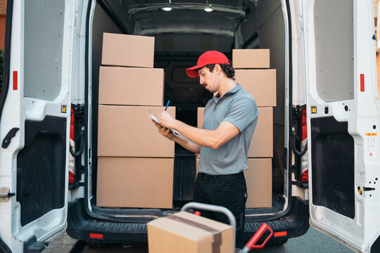 Delivery man checking packages in cargo van