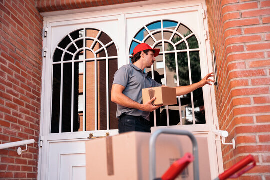 Delivery man ringing doorbell holding package