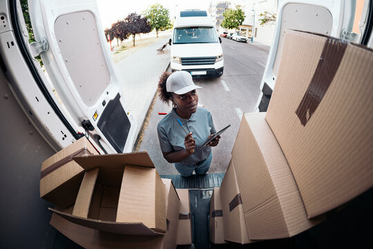 Woman courier checking packages for delivery