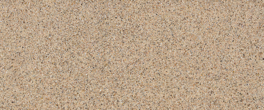 A detailed textured background of coarse sand with small pebbles and dark grains providing a natural and granular surface for design