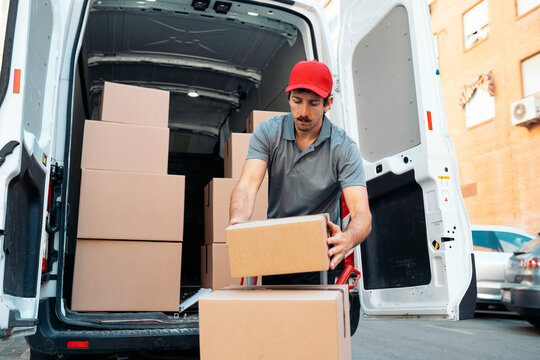 Courier delivering cardboard packages from van