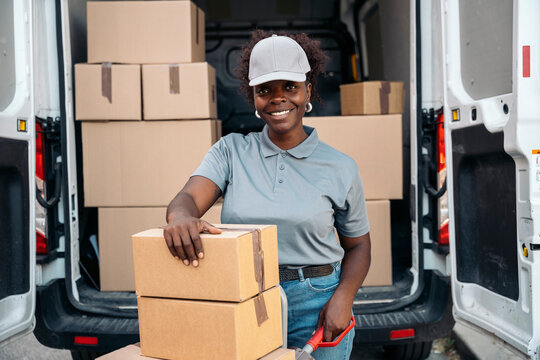 Woman courier delivering packages from delivery van
