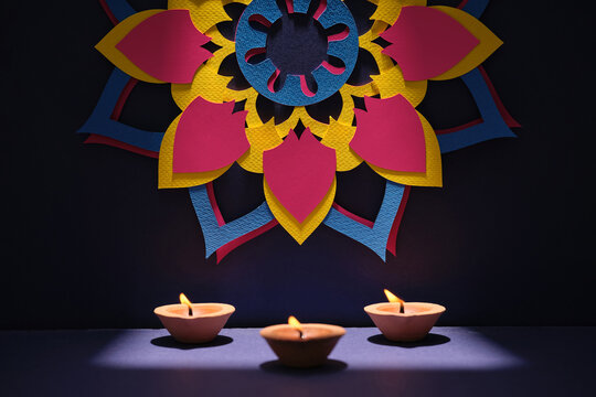 Diwali diyas illuminate a vibrant paper mandala