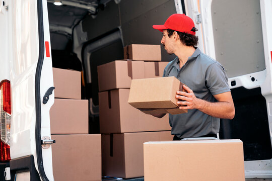 Delivery man unloading shipping packages from van