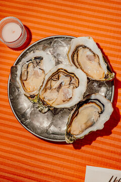 Fresh raw oysters on ice served on a metal platter