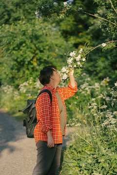 A woman inhales the fragrance of flowers.