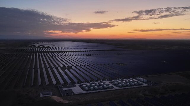 Stunning Sunset over Vast Solar Panel Farm in Remote Sandy Desert Landscape