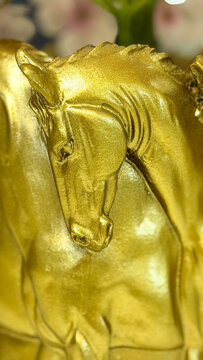 Close-up of a decorative golden horse sculpture with metallic finish, elegant equestrian home decor detail.