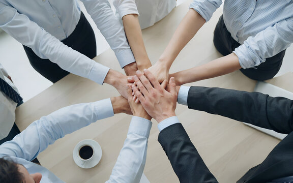 Diverse business team joining hands in a collaborative meeting gesture during a strategy session