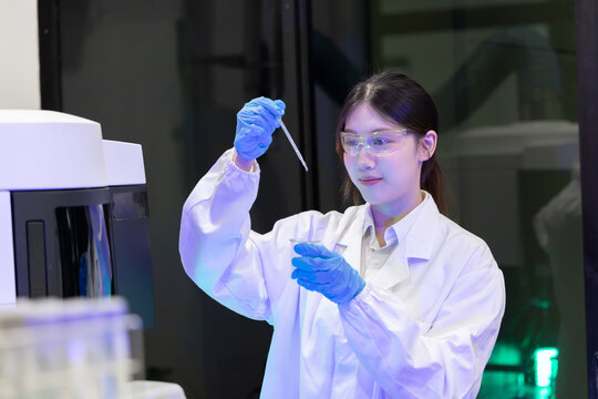 Laboratory technician conducts experiments with test tubes and microscope in a modern research facility