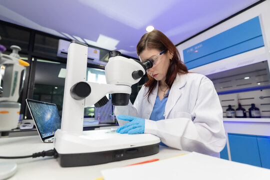Scientist looking through a microscope in a laboratory