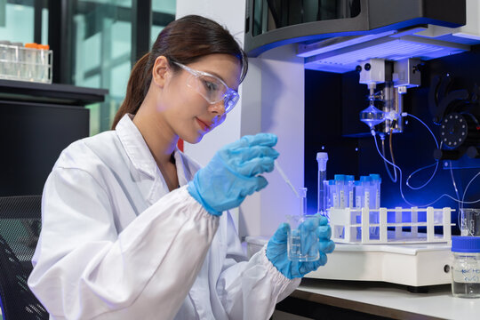 Laboratory technician conducts experiments with test tubes and microscope in a modern research facility