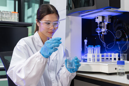 Laboratory technician conducts experiments with test tubes and microscope in a modern research facility