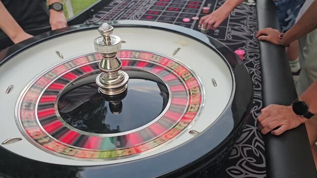 People play roulette at a gathering in an outdoor setting during a sunny afternoon