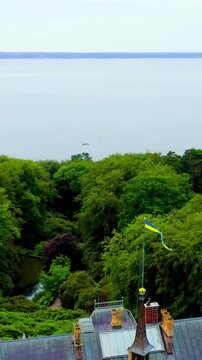 Vertical video. Sweden. Sofiero Palace, Dutch Renaissance summer residence with gray slate roofs and copper spires, Drone footage revealing lush parkland and the Oresund Strait beyond.. Drone footage