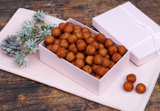 Traditional German marzipan potatoes in a pink box with Christmas decorations.