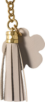 beige leather tassel keychain isolated white background, flower shape and gold metal chain hardware accessory side view in macro close-up