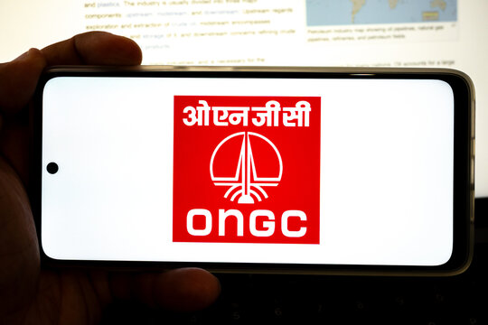 Hand holding device displaying ongc logo