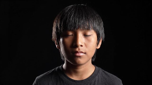 Portrait of an Asian Teenage Boy on a Black Background