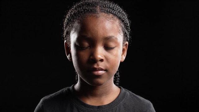 Serious Young Black Girl Portrait on Black Background