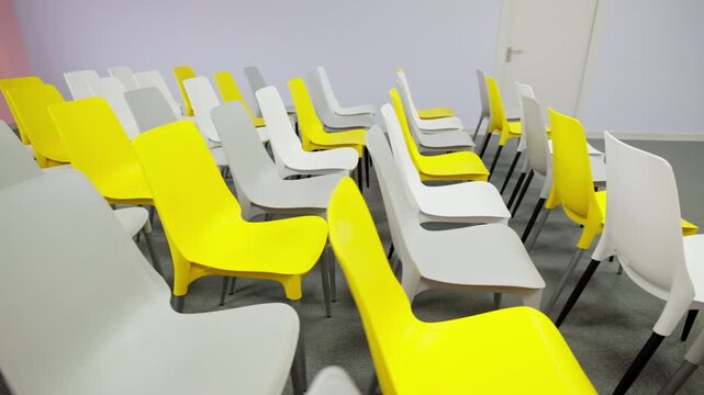 Alternating chair colors create dynamic visual pattern in lecture hall. Neat seating arrangement provides optimal capacity for seminars